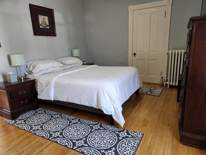  Спалня на основния етаж с щедър килер и голямо двойно легло.