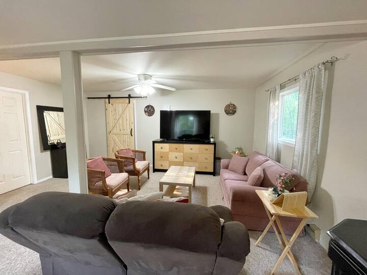 Bright and spacious living area with 65" TV, sitting area for 6-8 people.