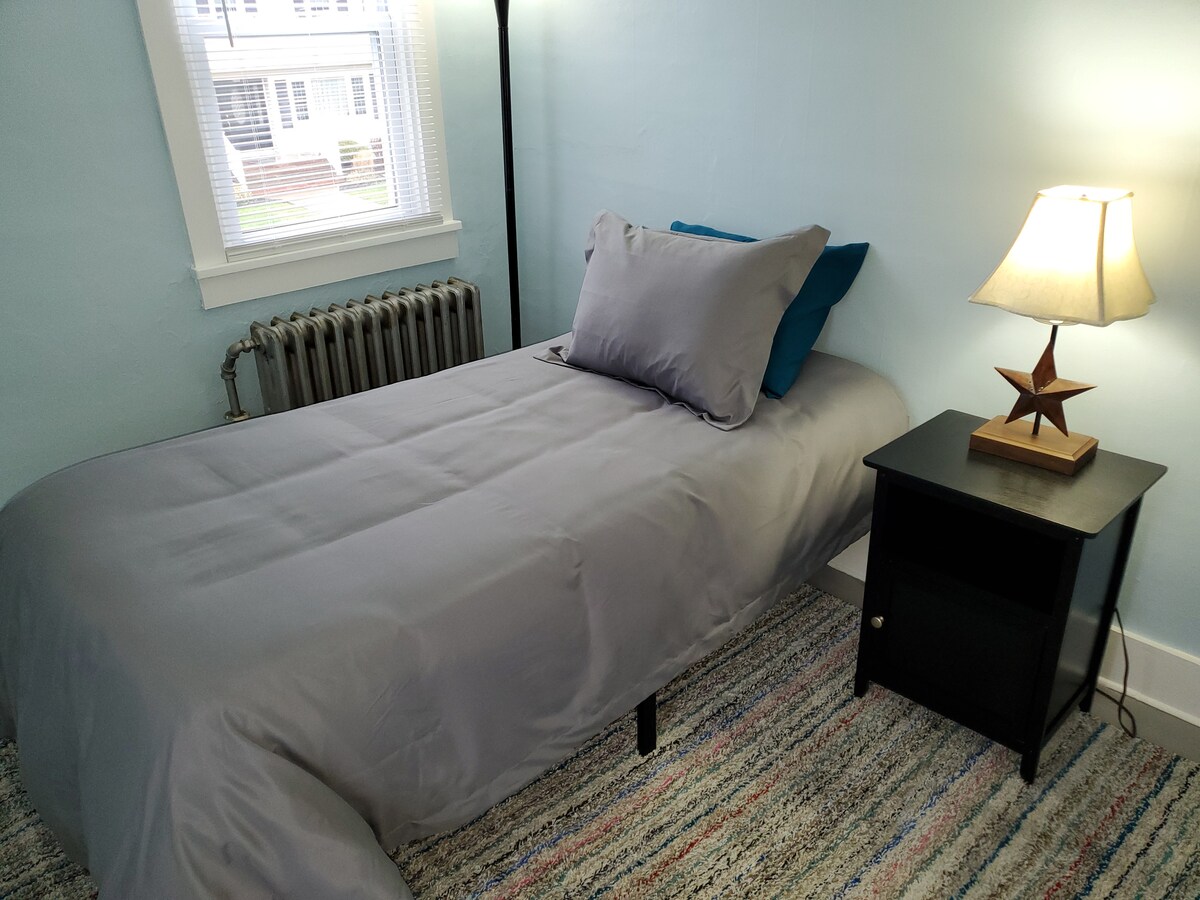 Chumba cha kulala cha Mgeni #1 - Juu ya ngazi zilizo na kitanda pacha.  Wakati wa majira ya joto, kitengo cha dirisha a/c kitawekwa kwenye dirisha karibu na kitanda.