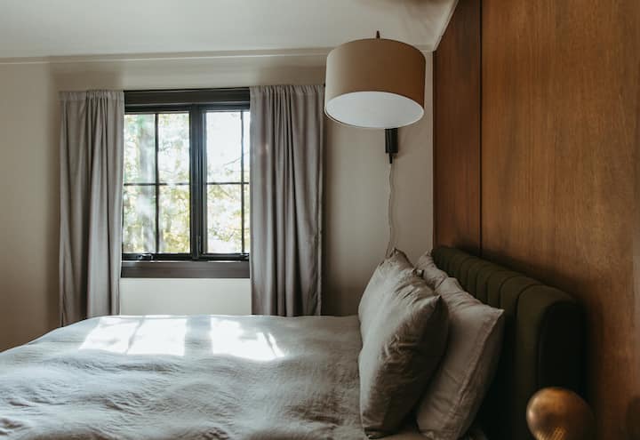 Dormitorio trasero con cama tamaño queen, espacio de trabajo y TV