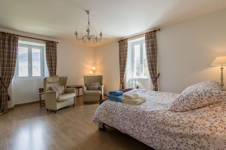 Chambre parentale à l'étage : spacieux avec fauteuilles et une penderie.