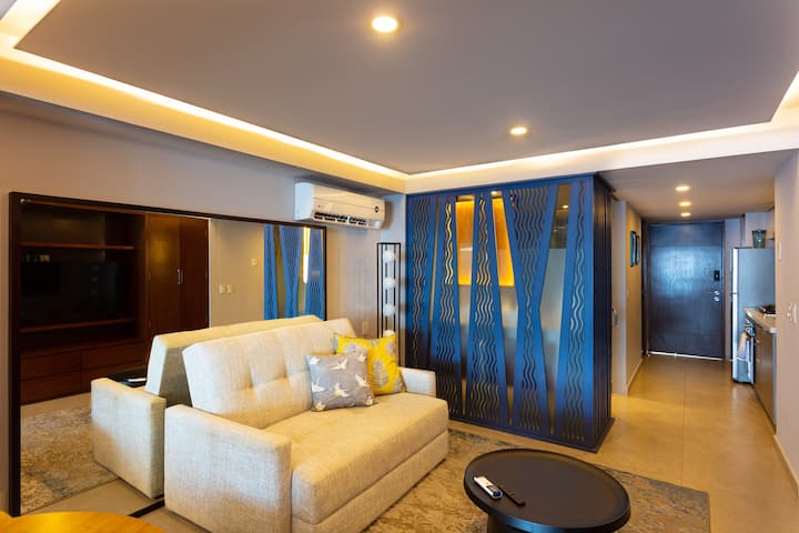 พื้นที่ห้องนั่งเล่นที่สะดวกสบายพร้อมสมาร์ททีวีและเครื่องปรับอากาศ