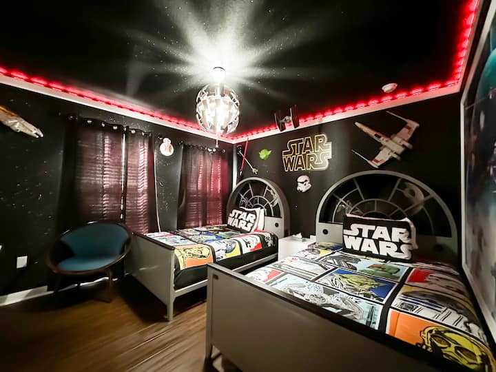 Ingia kwenye galaksi ya mbali, mbali katika ghorofa hii ya ghorofa ya kati: vibanda viwili vya kulala vilivyopambwa kwa mito ya Grogu na matandiko ya ulimwengu, chini ya dari ya ukutani iliyojaa nyota, trim ya bluu inayong 'aa ya LED, na lahaja za galaksi-kila usiku, nyota maarufu ya Star Wars odyssey. 