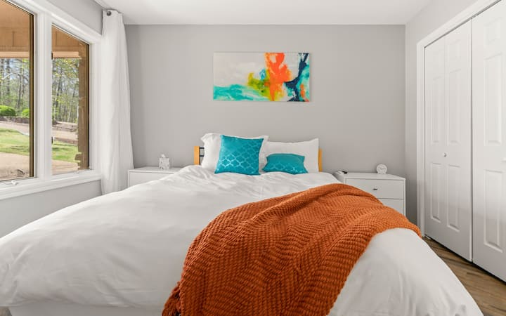 Chambre d'invité élégante avec des touches de couleur et de la lumière naturelle.