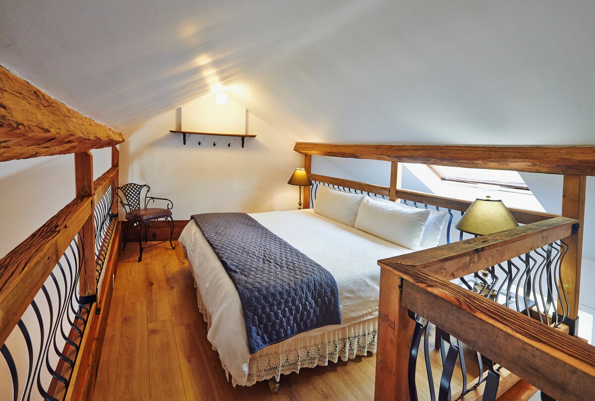 宽敞的加大双人床主卧是一间令人惊叹的阁楼，三面有栏杆，可欣赏下层大房间。质朴的硬木地板完善了公寓这一区域的魅力。