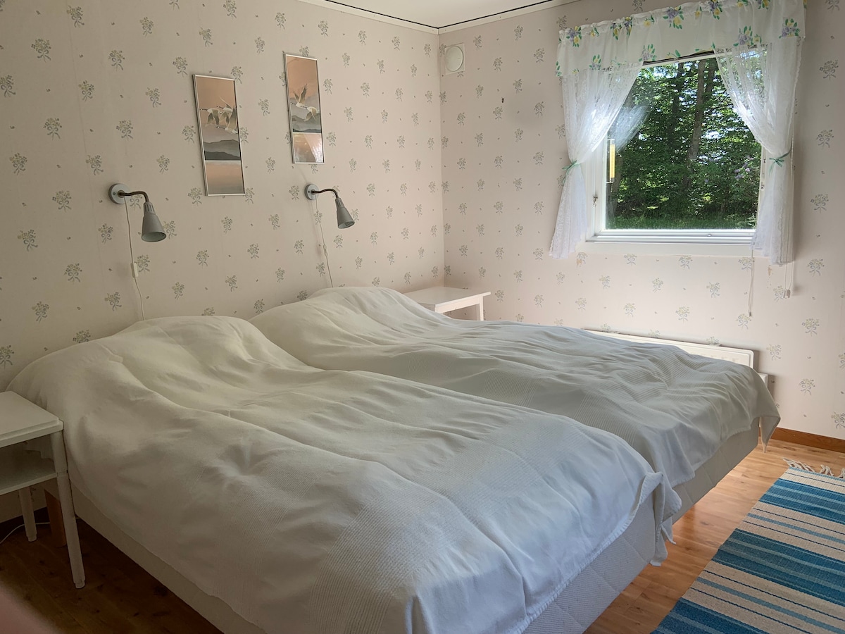 Spavaća soba s dva kreveta od 90 cm, ladicama i ormarom.