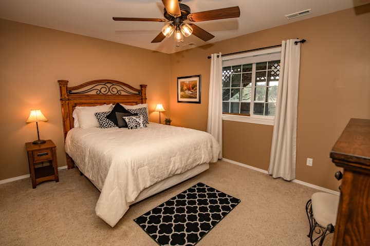 Спалня на долния етаж с двойно легло и прилежаща баня.  Roku TV.  