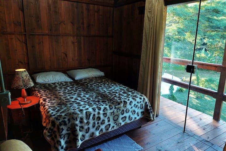 غرفة نوم في الطابق الثاني ، مع جدار  خشبي ونوافذ زجاجية ، تطل على الغابة . سرير مريح للأزواج ، (اختياري: مرتبة مع قش الذرة).