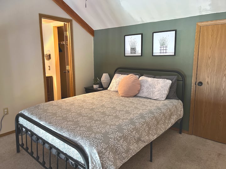 The upstairs bedroom is a loft style bedroom and looks down into the main living area. The queen mattress features all new linens and the bedroom has a private bathroom. 