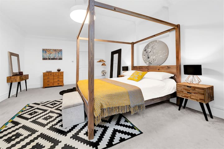 غرفة نوم كبيرة مع غرفة استحمام داخلية وسرير بحجم كينغ بأربعة أعمدة في المملكة المتحدة (150 سم × 200 سم). ملاحظة: تقع هذه الغرفة في مقدمة العقار - هناك زجاج ثانوي، ولكن قد يكون هناك بعض الضوضاء من الطريق.  