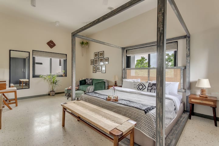 Master bedroom with a 4 poster bed, a seating area and a vanity