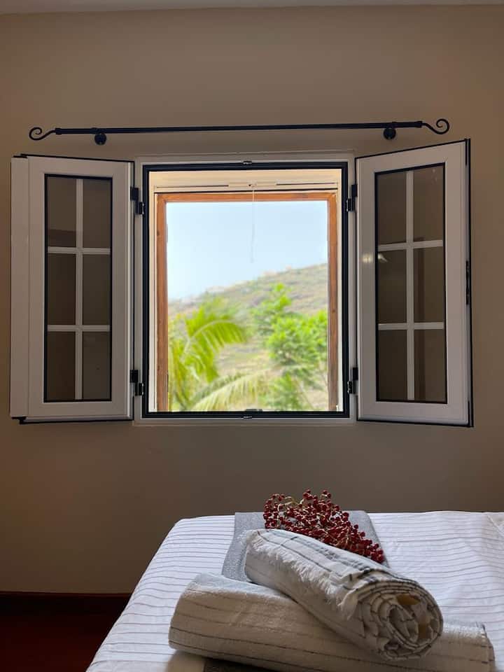 Chumba cha kulala 1: Mtazamo wa mandhari ya kijani ya bonde kutoka kwa chumba cha kulala.