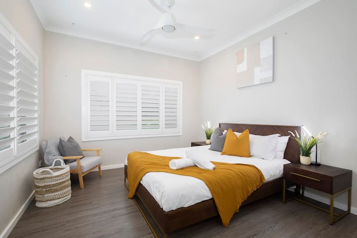 A beautifully styled main bedroom comes with a reading nook and ceiling fan to keep you comfortable.