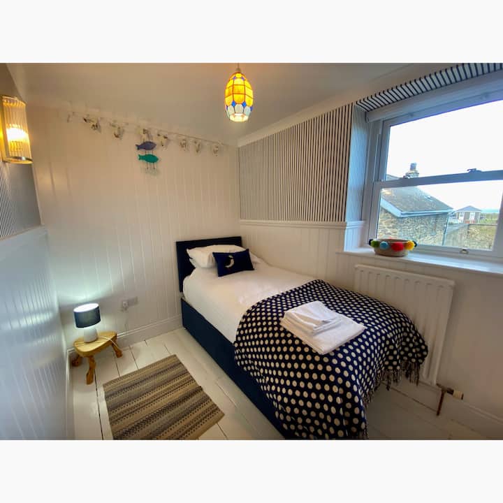 Საძინებელი 4. ერთადგილიანი საწოლით და კარდიგანის ყურეზე ხედებით.