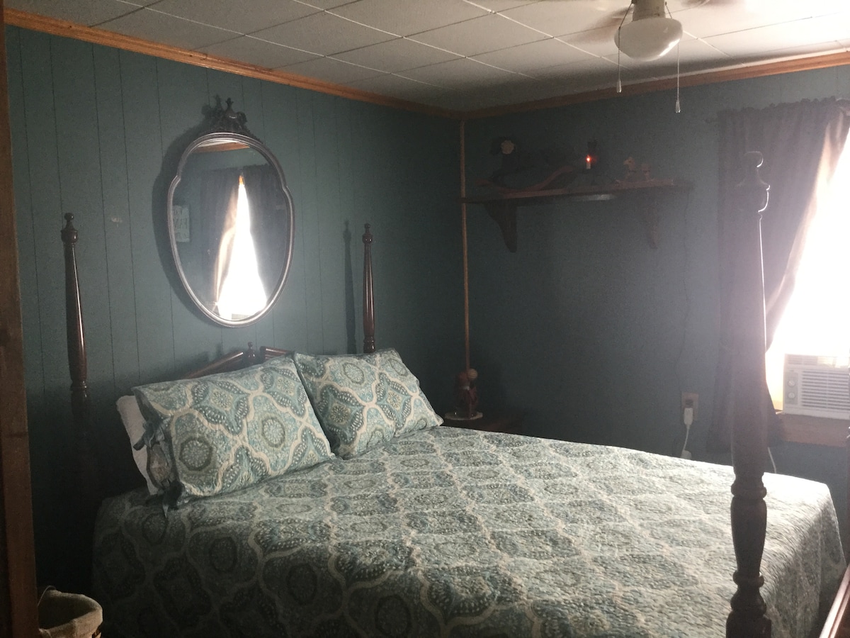 Chambre avec lit queen et commode.