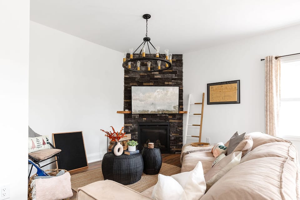 The Huntsville cottage living room, with a stone fireplace and seating for the company