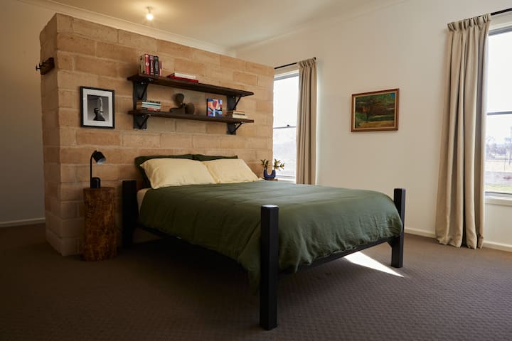 Bedroom 1: Queen size comfy bed with soft flax linen sheets and doona in spacious room. Garden views and air conditioner