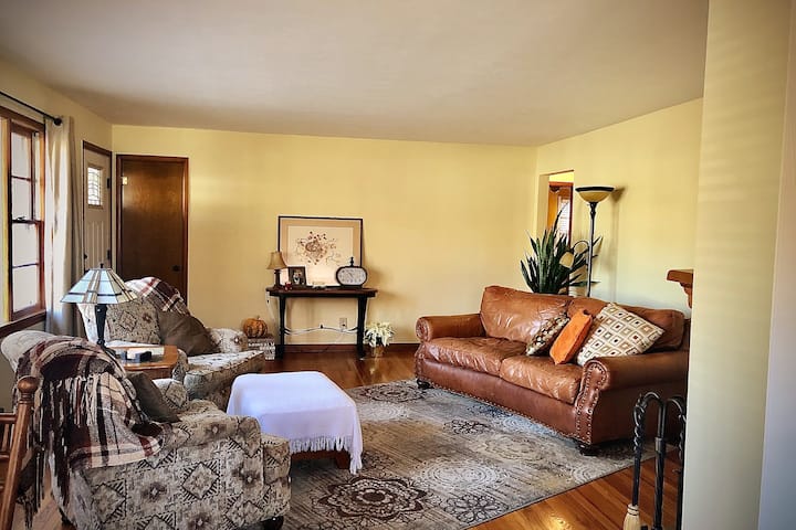 غرفة معيشة رقم1 مع أريكة جلدية يمكن استخدامها لمساحة نوم إضافية ومدفأة تعمل بحرق الخشب