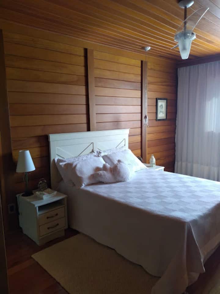 Spavaća soba za goste s panoramskim pogledom na prozor.