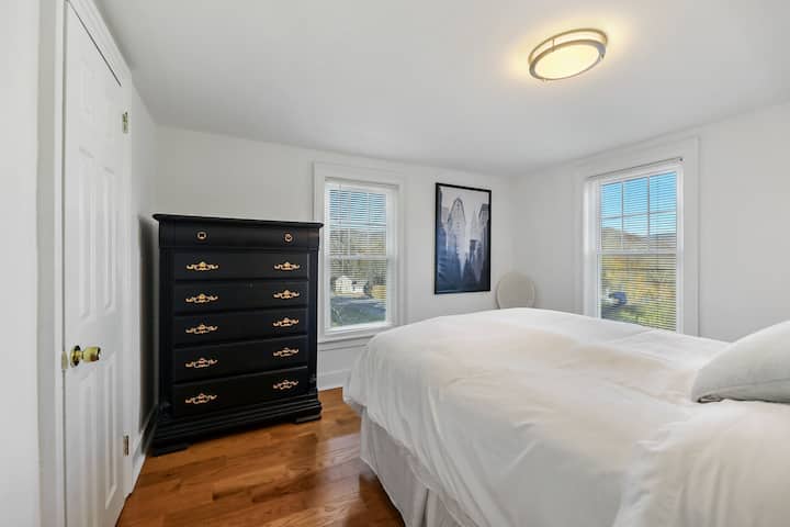 A plush Queen mattress awaits on the second floor in bedroom #2, with stunning views of the garden from the window and complete with a chest of drawers.