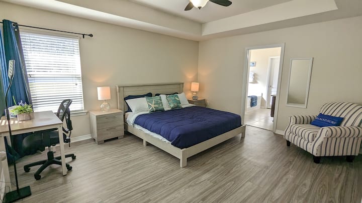 The second bedroom offers a comfortable king-size bed and a perfect workspace with a serene backyard view—ideal for work and relaxation.