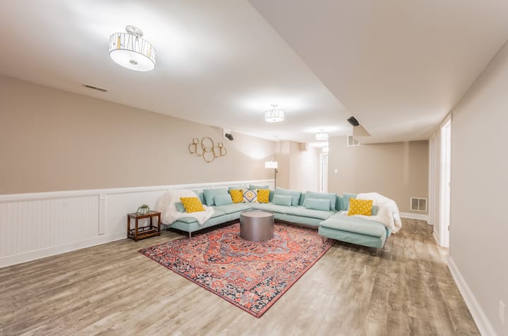 Linda zona de sótano bohemio con un enorme y cómodo sofá modular. ¡El lugar ideal para las noches de cine! 