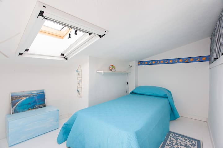غرفة نوم مفردة ثالثة في الطابق العلوي ، مضاءة بواسطة velux تلقائيًا ومكتملة بمصباح مريح على رف واسع وخزانة ملابس لتخزين المتعلقات الشخصية.