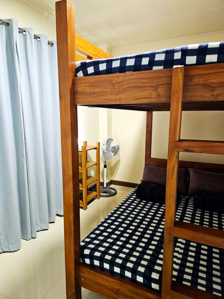 Si bien esta habitación puede ser compacta, ofrece un espacio acogedor y eficiente para que hasta cuatro huéspedes descansen y se recarguen en su litera. 