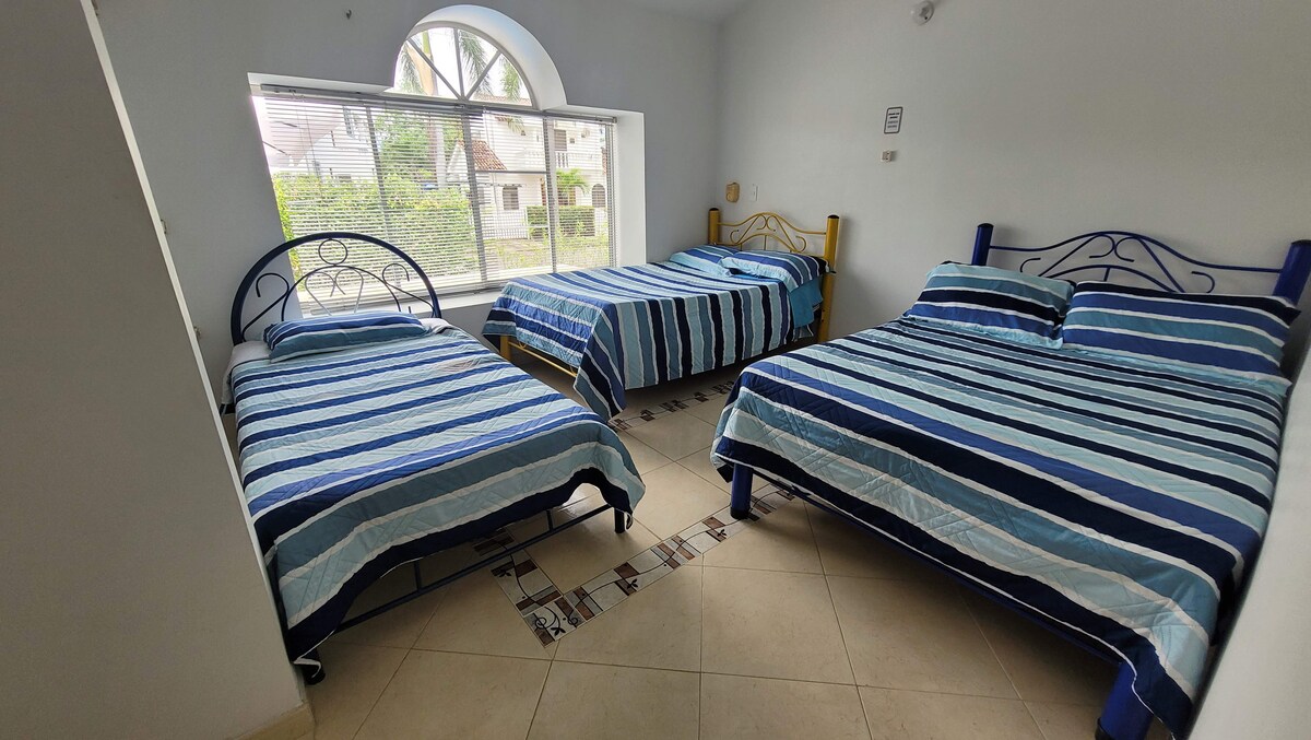 2号房配有吊扇、3张宽敞的床和泳池景观。