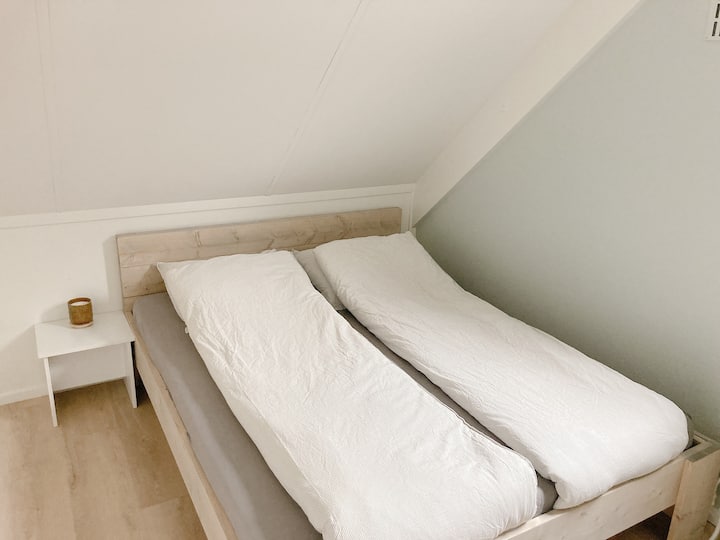 Საძინებელი 3: ზემოთ. ხის ორადგილიანი საწოლით 160 × 200 სმ და საუნით.