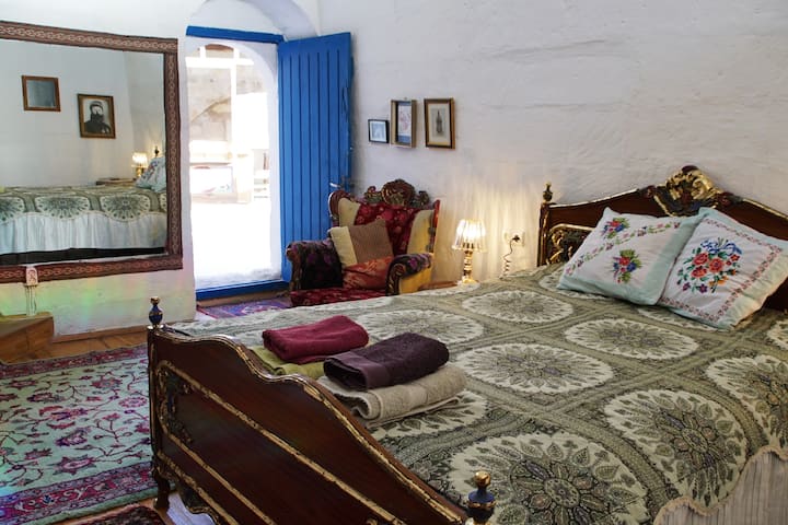 Pièce traditionnelle voûtée au plafond avec baignoire et céramique peinte à la main et œuvres d'art