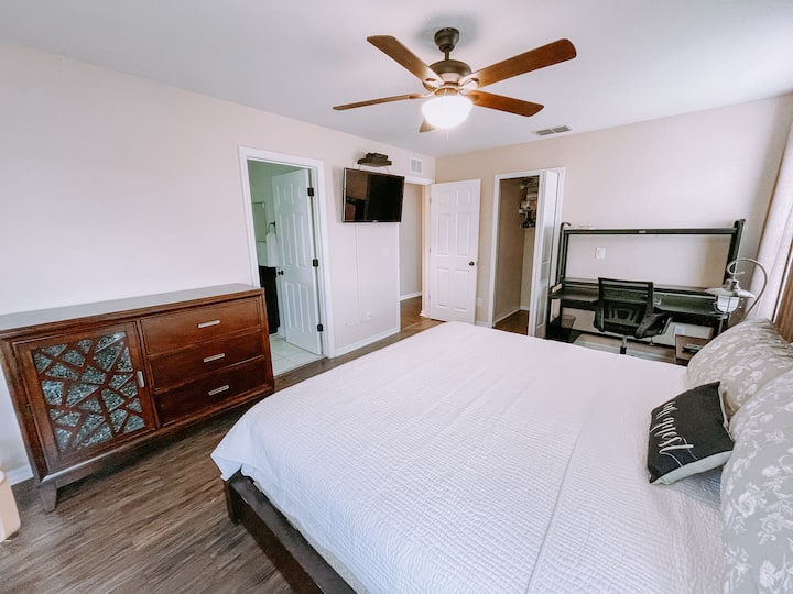 Hlavná spálňa na druhom poschodí s pripojenou kúpeľňou, televízorom, centrálnou klimatizáciou, stropným ventilátorom, šatníkom, priestorom na balkóne a písacím stolom na prácu z domu! Na stole nájdete bezdrôtovú klávesnicu a myš pre vaše pohodlie.