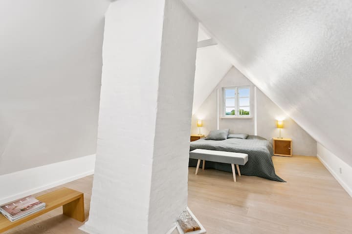 Habitación grande con cama matrimonial con vista a los campos