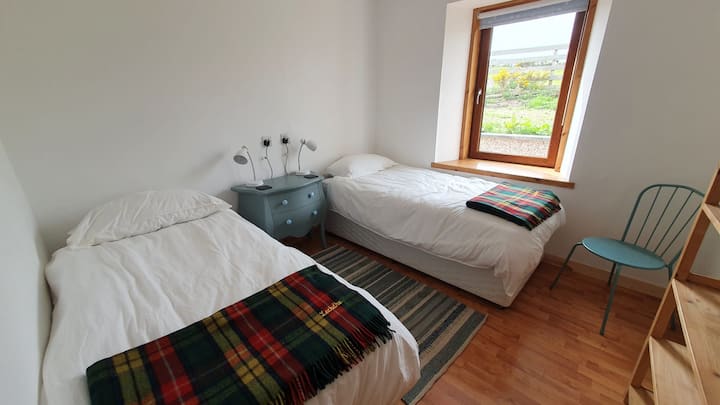 Twin bedroom with single and trundle beds, blackout blinds and garden view