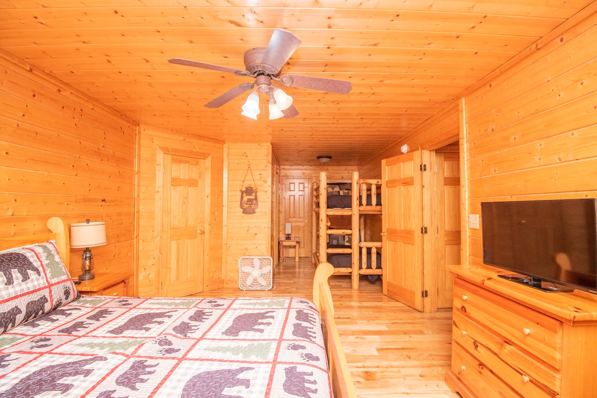 Amplio dormitorio en el nivel inferior con cama tamaño king, TV, baño privado en suite y literas individuales.