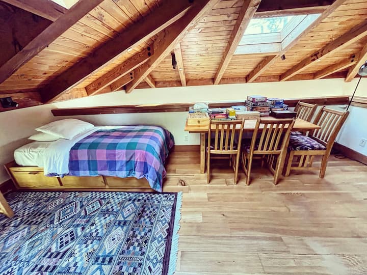 אזור לופט עם מיטה זוגית, שולחן משחקים ופינת קריאה