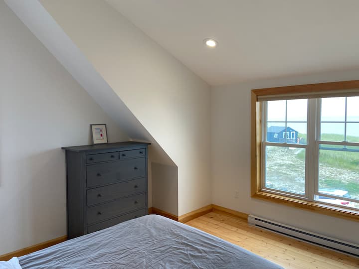 Veľká spálňa na 2. poschodí s manželskou posteľou Queen, komodou, 2 nočnými stolíkmi a písacím stolom. Izba má veľké okná, stropný ventilátor a úchvatný výhľad na oceán. 