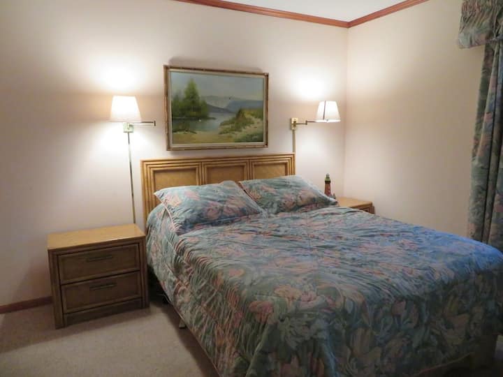 Спалната соба на повисоко ниво има брачен кревет и комплет кревети на спрат.