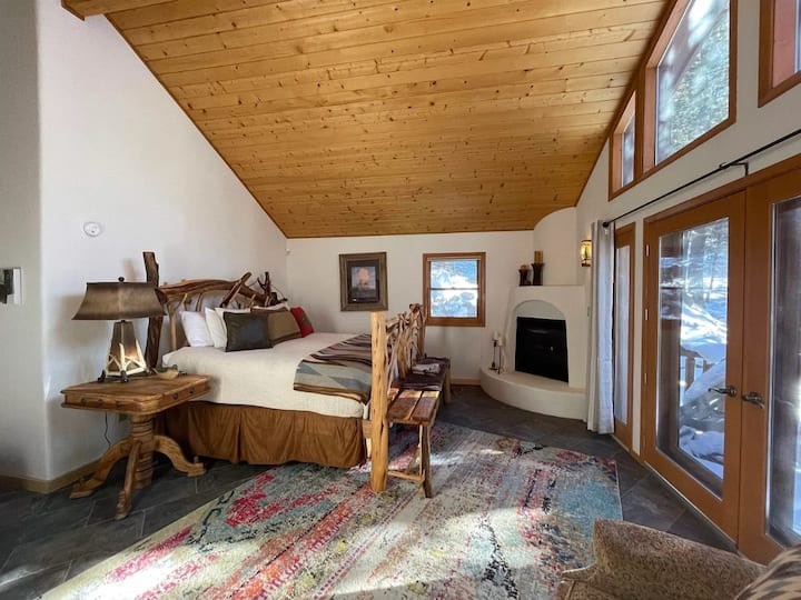 Incredible master bedroom with comfortable king-sized bed, gas fireplace, private deck, sitting area, 42-inch smart TV, and en-suite bath.