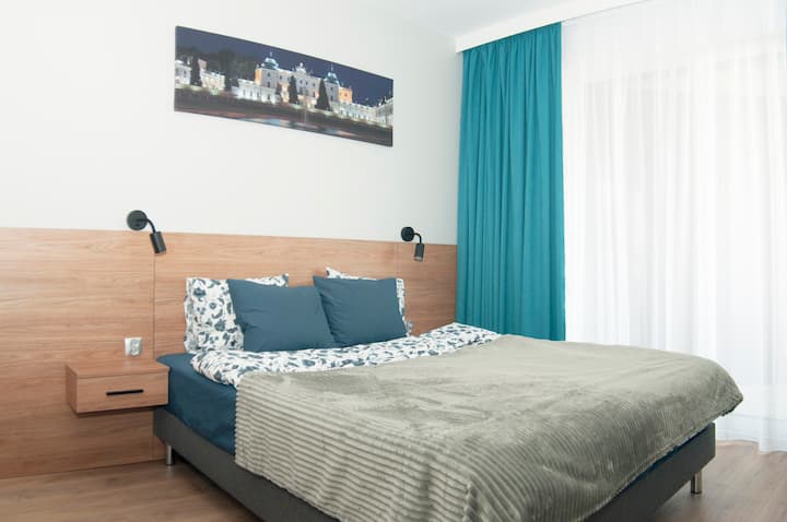 Спалня, широко удобно легло. Нощни шкафчета, лампи за четене. Завеси на прозорци.