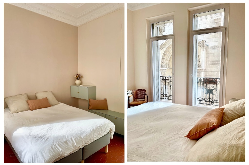 A spacious bedroom is presented with two beds topped with neutral linens and soft pillows. Large windows brighten the room, revealing glimpses of a balcony with decorative wrought iron railings. A minimalist dresser stands against the wall, accentuating the room's simplicity and elegance.