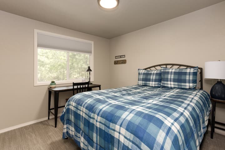 Dormitorio con cama tamaño queen y escritorio