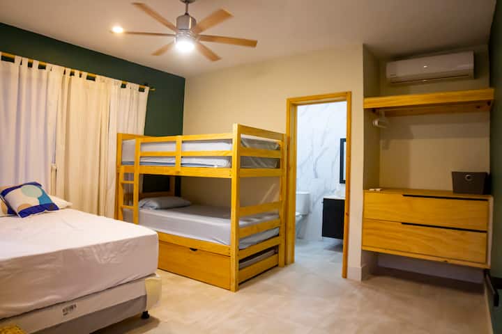 Quarto 3 com camas confortáveis, banheiro próprio, A/C, espaço de armazenamento.