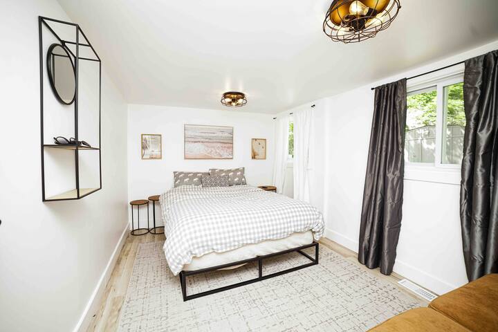 Camera 1 con letto matrimoniale, tende oscuranti, TV e divano.