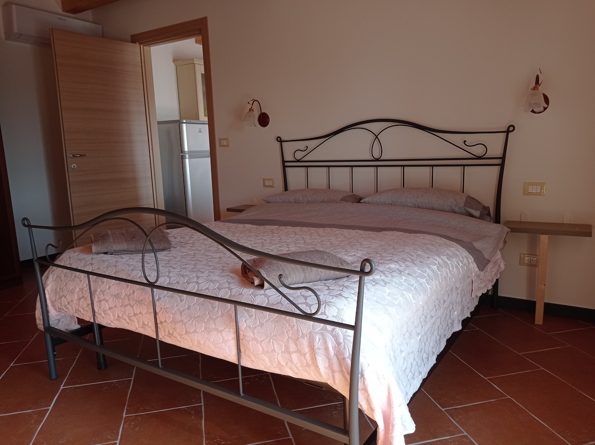 Kitanda maridadi cha watu wawili kilicho na godoro la sponji kwenye chumba cha kulala chenye kiyoyozi.