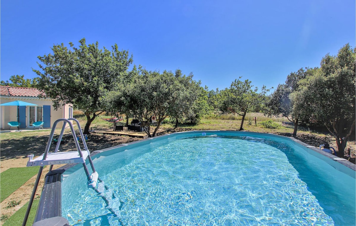 A private swimming pool is featured, surrounded by lush greenery and trees, creating a serene outdoor space. The pool's clear water reflects the blue sky above. A ladder is positioned at one end for easy access.
