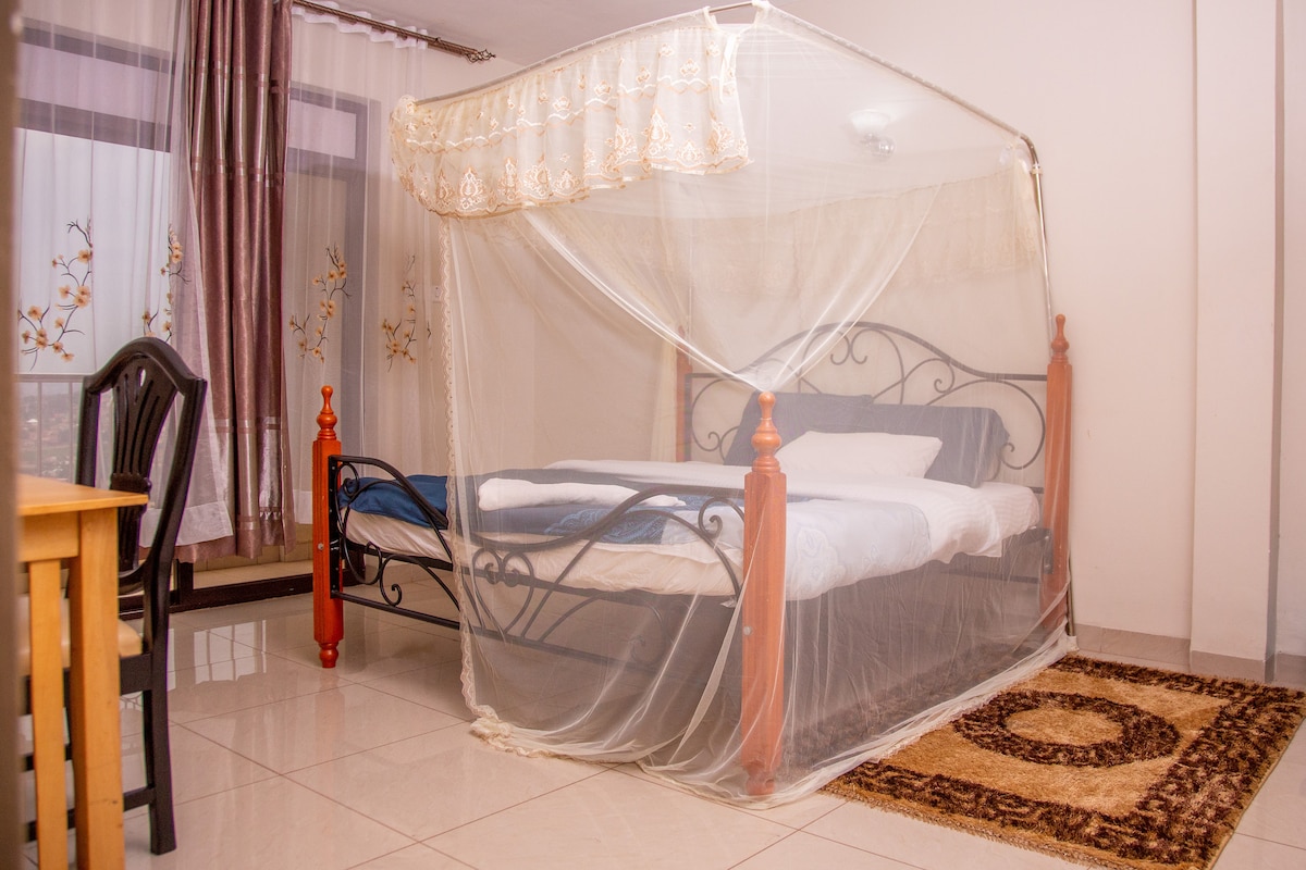 Spavaća soba s udobnim krevetom i radnim stolom.