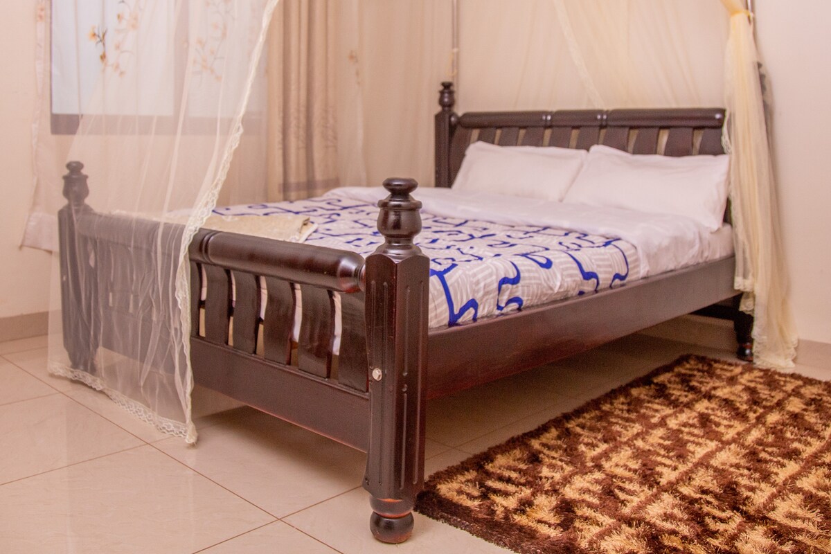 Spavaća soba s udobnim krevetom i radnim stolom.