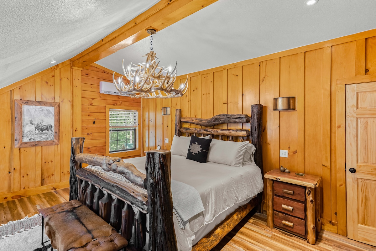 King Suite bedroom with mini-split a/c, beautiful hand crafted, local, log furniture, and 3 tier antler chandelier