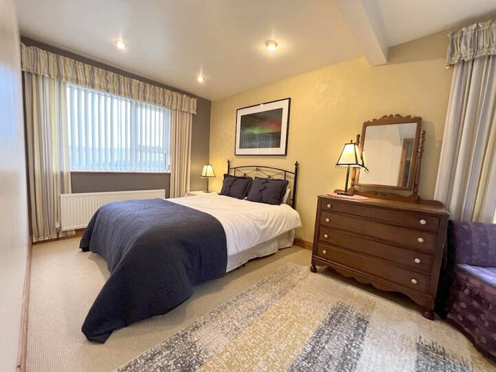 Chambre principale au 1er étage avec des portes donnant sur le patio.